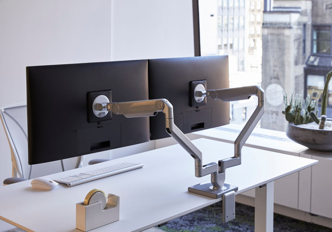 Bras Humanscale M2 Pro réglés pour deux écrans, vue de biais