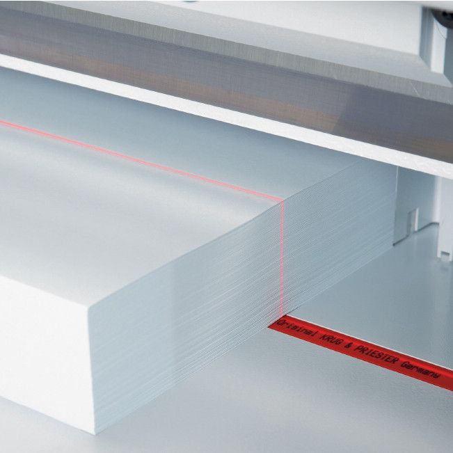 Réglette de coupe rouge en place sous la pile de papier, dans la table d’un massicot IDEAL