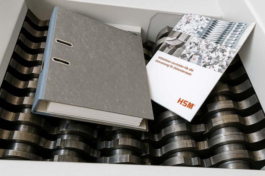 Vue rapprochée d’un destructeur de documents industriel HSM avec brochures sur tambour de coupe en acier – Arboreal France
