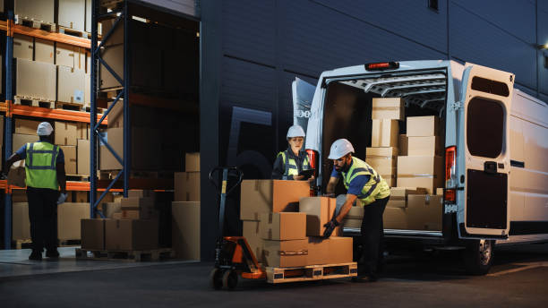 Chargement de colis dans un entrepôt logistique, avec un camion de livraison ouvert et des opérateurs en gilets de sécurité – Illustration d’une chaîne d’approvisionnement efficace pour les entreprises B2B