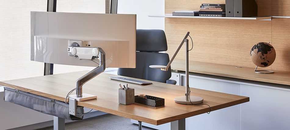 Poste de travail ergonomique équipé d’un bras support écran Humanscale, dans un bureau moderne en bois clair – Mobilier professionnel haut de gamme pour espaces tertiaires